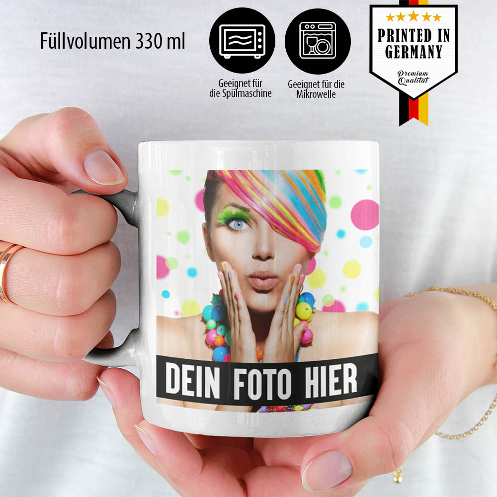 Person hält Fototasse mit buntem Motiv und Text 'Dein Foto hier', spülmaschinengeeignet, 330ml